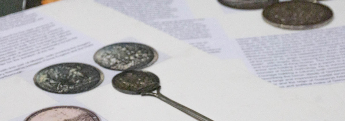 Historic medals resting on printed research notes